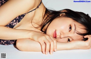 A woman with long black hair and bangs is posing for a magazine.