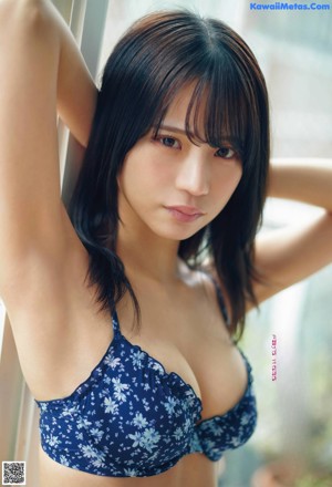 A woman in a black bathing suit sitting on a table.