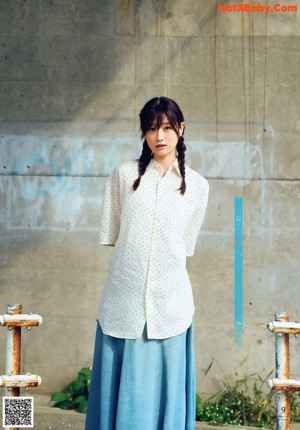 A woman in a blue dress posing for a picture.
