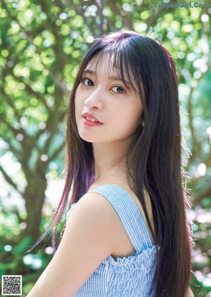 A woman with long black hair wearing a blue dress.