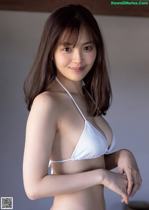 A woman in a white shirt is sitting on a tatami mat.