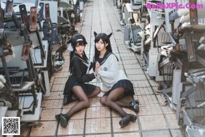 A couple of young women sitting on top of a chair.