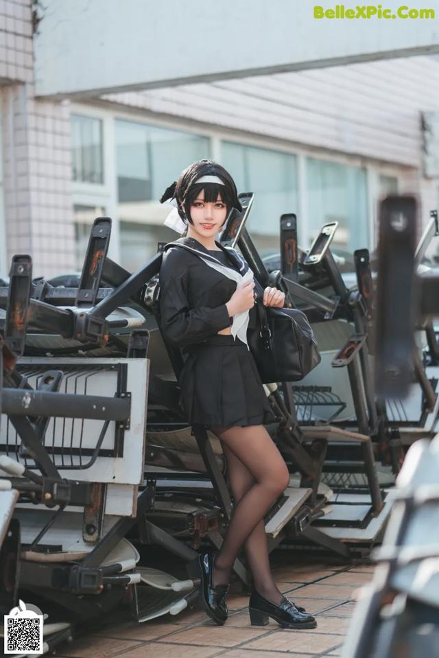 A woman in a black and white uniform posing for a picture.