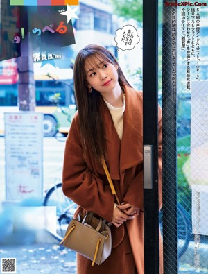 A woman standing in front of a store with her arms crossed.