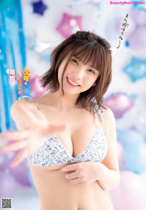 A woman in a bikini holding a water gun.