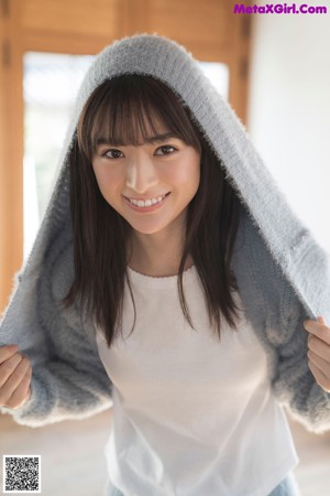 A woman in a blue sweater and skirt posing for a picture.