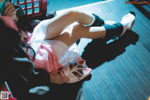 A woman in a pink kimono laying on the floor.
