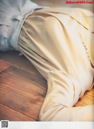 A woman sitting on the floor with her legs crossed.
