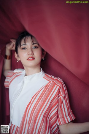 A woman wearing a red and white striped shirt and a pair of earrings.