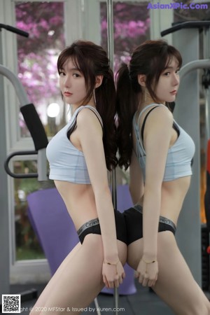 a woman in a white top and denim shorts posing for the camera