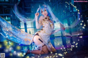 A woman with long blue hair is posing on some stairs.