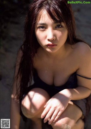A woman in a white bra and panties posing in the mud.