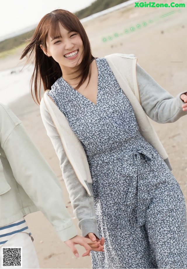 A woman in a blue and white dress holding hands with a man.
